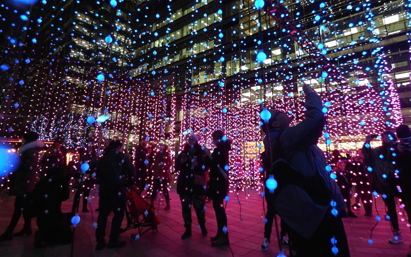 Tourist exploring Canary Wharf Winter Lights in London 