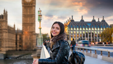 A girl posing in front of Big Ben in London.